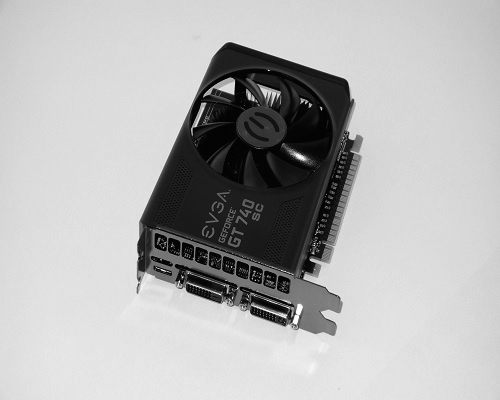 The graphics card of GEFORCE GT 740 SC is rectangular. It displays two external connection pins to display devices with a cooling fan at its center is shown in the photograph.