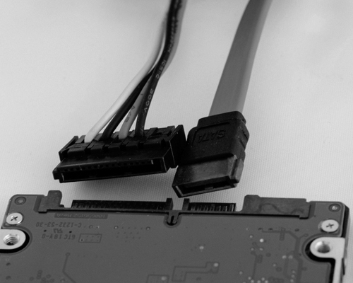 A photograph of a SATA data cable unplugged from a device is shown.
