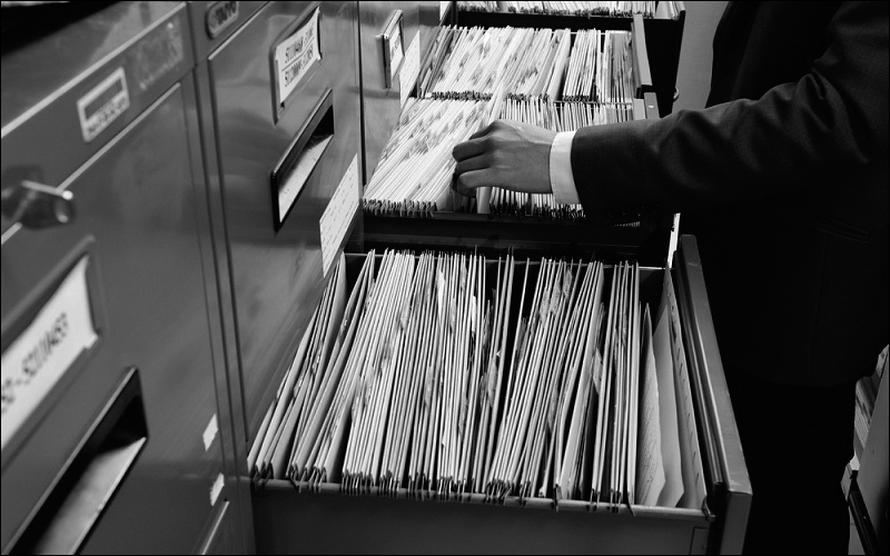 Photograph of a person picking a file from cabinets.