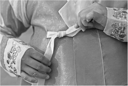Figure 22.1 Tying the Traditional Hanbok Source: Photo by Laura Elizabeth Pohl.