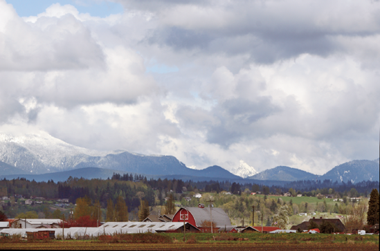 The Canon EF 70–200mm f/2.8L, IS, USM telephoto zoom lens brought this farm and mountain scene closer. The exposure was ISO 100, f/9, 1/400 sec.