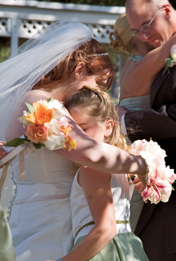 This photo illustrates an unstaged shot that captures both the bride and the groom interacting with their family members after the wedding ceremony.