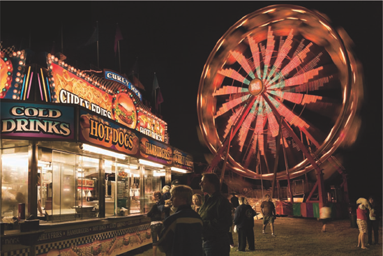 A slow shutter speed of 1/6 second shows the motion of the Ferris wheel as well as the motion of people walking. Exposure: ISO 400, f/11, 1/6 second using a −1/3 stop Exposure Compensation.