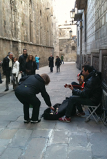 A woman giving money to musicians playing on the street.