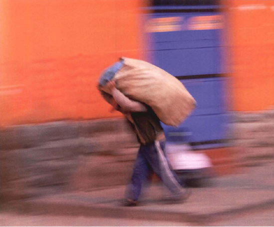 In the small villages of Peru, the main method of transporting things is by carrying them. All day long people lumber by under large loads. Exposure at 1/5 second, f/4.5.