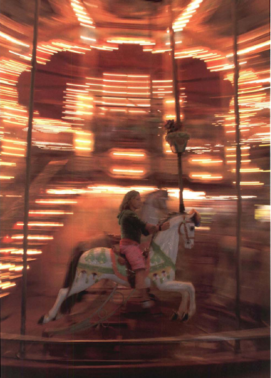 What technique could better capture the carnival atmosphere of a merry-go-round at night? Exposure at 1/6 second, f/9.