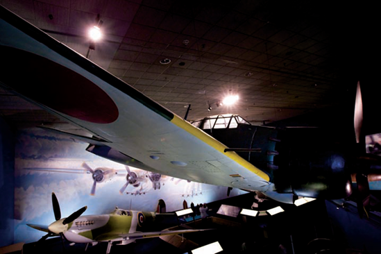 Using light behind the subject for a more dramatic effect: A Mitsubishi A6M5 Zero (above) and a Supermarine Spitfire F.Mk.VII in the World War II Gallery at the National Air and Space Museum. Taken at ISO 3200, f/4, 1/40 second with a 20mm lens.