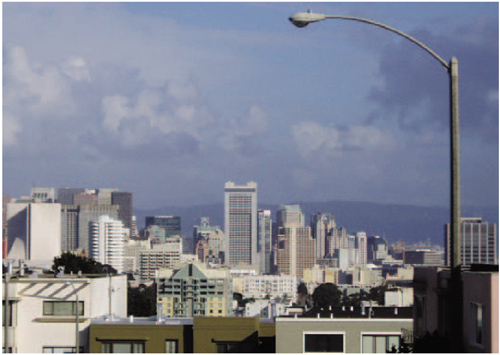 This shot was taken with a long lens. The structures one block away retain a good deal in the black of their shadows; buildings a mile or two away, far less; and the foothills ten miles away are so desaturated they begin to fade right into the sky—at first you don't even notice them. The feeling of the shot is one of proximity to a crowded urban environment but with nature always waiting just beyond.