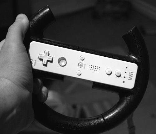 The author holding the Ubisoft steering wheel.