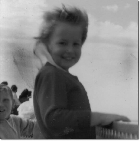 This is a very lovable shot of a child on a boat in 1965 at Cape Cod. The many problems shown in this zoomed-in view of the photo have Photoshop solutions.