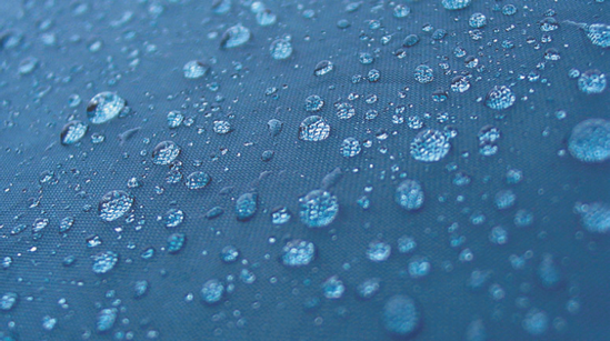 Water droplets refract the cloth they sit on.