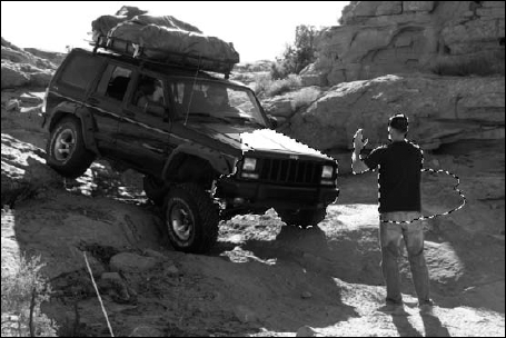 Make a selection to create a mask that hides the areas of the snowman that should be behind the man and the Jeep.