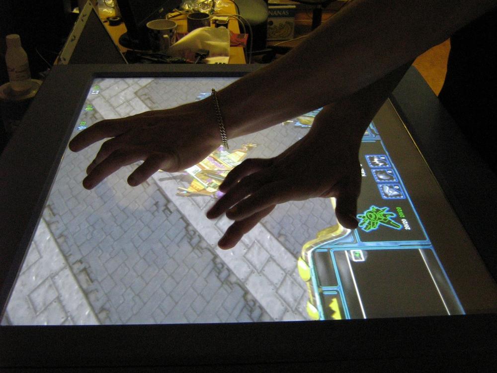Designers experimenting with a multitouch system to play Starcraft with two hands. Courtesy Harry van der Veen and Natural User Interface.