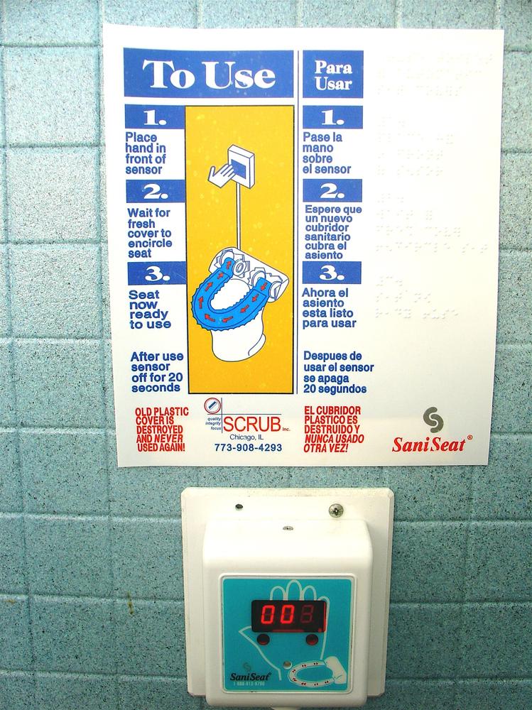 This SaniSeat shows where the hand is placed, but the rest of the system is so complicated (at least for a public toilet) that it requires a poster to explain.