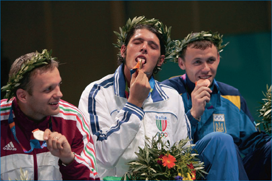 Here, Italian saber champion Aldo Montano literally licks his gold medal for all the cameras at the Athens 2004 games.