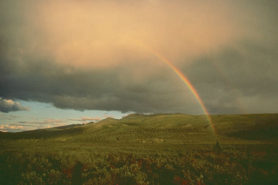 Clouds and a rainbow help emphasize the grandeur of this landscape.