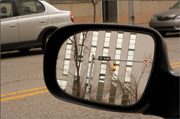 By focusing on the reflection in the rearview mirror and using a narrow f/22 aperture, the reflected scene and the objects across the street are very sharp, and even the rearview mirror frame is not completely out of focus.