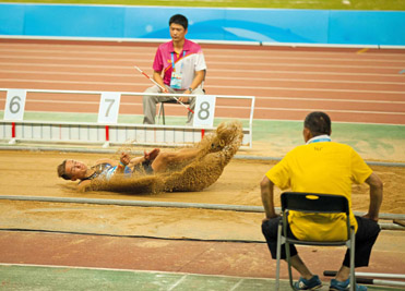 Figure 9.9 A contact microphone being buried in the sand at a long jump competition. The microphone picks up the vibration of the landing.