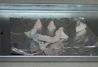 Clay face pieces are baked in an oven for hardening.