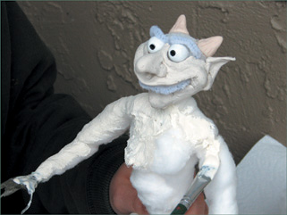Liquid latex rubber is brushed onto the puppet.