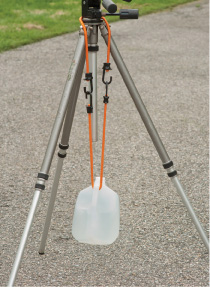 Use a bungee cord to attach a water jug to a tripod to make it more solid, and to help prevent camera shake. Copyright © Steve Weinrebe