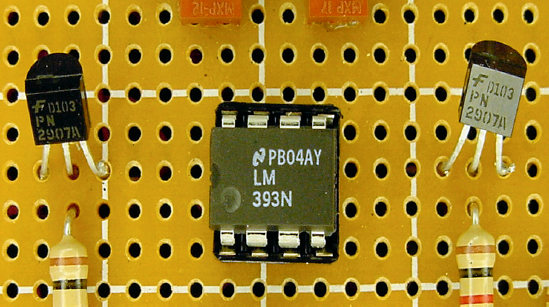 Comparator (center) flanked by two transistor switches (left and right)