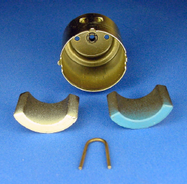 A pair of permanent magnets removed from the metal can. The clip in the foreground keeps the magnets from sliding together.