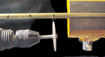 Rotary tool with cut-off wheel (lower left) about to cut through tubing at marked locations. The tubing is held firmly within a vise (right)