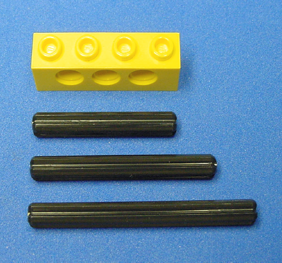 Three example lengths of LEGO cross axles beside a 4 LEGO unit brick (top) for comparison purposes