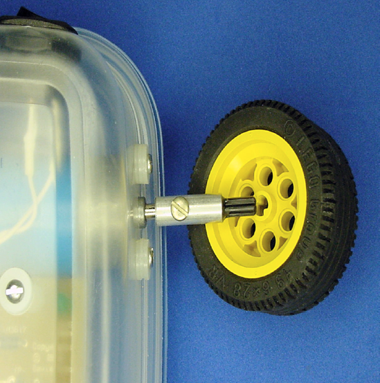 Sandwich with the coupler attached to the motor shaft and a LEGO wheel about to be pressed on