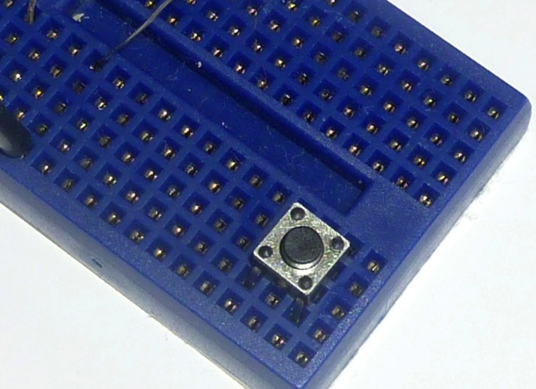 The pushbutton is inserted into the mini breadboard in a specific way