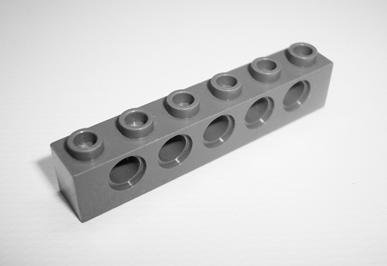 Notice the holes in the sides of this TECHNIC brick, where pegs or axles can snap in.