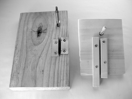 Here are two versions of the simple pipe-bending jig. The one on the left is made from a pair of shelf brackets and uses a 1/2″ drill bit as the bending guide; it makes a counterclockwise coil. The jig on the right is scrap wood, with a Sharpie marker slid through a 1/2″ hole in the board as a bending guide, and makes a clockwise coil. Both work great.