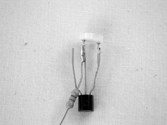 Here is the transistor with both resistors soldered to its base (the center leg). The connections to the collector—the transistor leg on the far right—are not soldered yet.