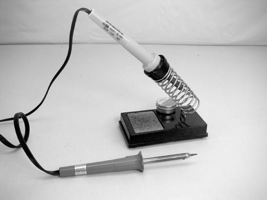 Here are a 15-watt (bottom) and 25-watt soldering iron with stand (top). The damp sponge in the stand is used for cleaning the tip, although many tinkerers prefer to use a copper scrubbing pad or old bolt instead.