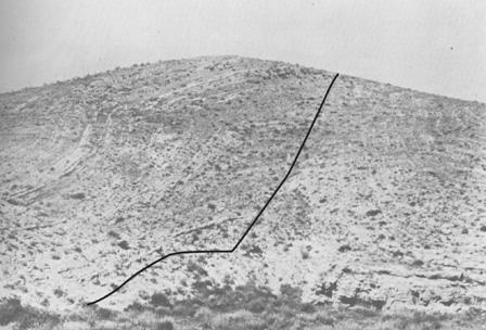 Box-like detachment fold in Pecos County, New Mexico, USA along a long, arcuate fault system that appears to contain restraining and releasing bends. In the photograph, the strata are folded above the bend in the fault surface, similar to Fig. 12-22.