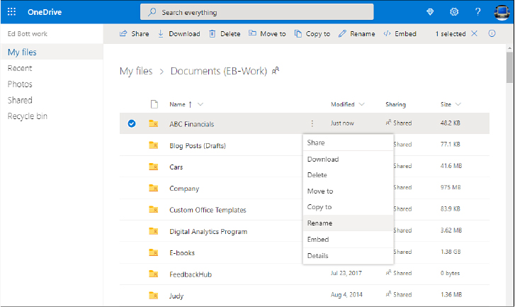 This screenshot shows a web browser with a header labeled OneDrive and a box to its right labeled Search Everything. Below that is a command bar over a list of folders. A menu containing file management commands is open next to a folder that is selected.
