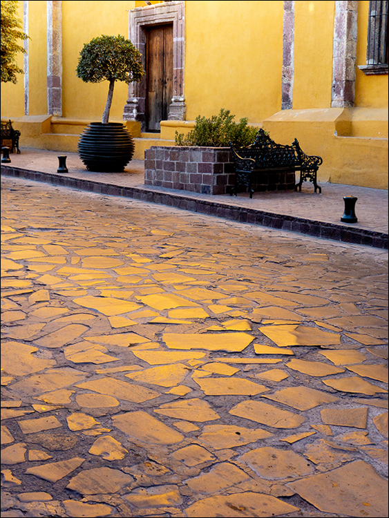Photo depicts the cobblestone streets which can reflect the same color as the nearby buildings.