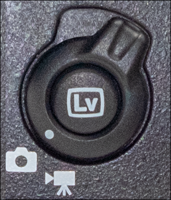 Image of the live view button to set the live view selector to live view photography; the icon below resembles a camera.
