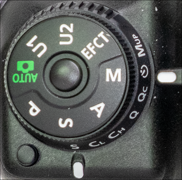 Image of the mode dial lock release for choosing the manual (M) mode to shoot a long exposure.