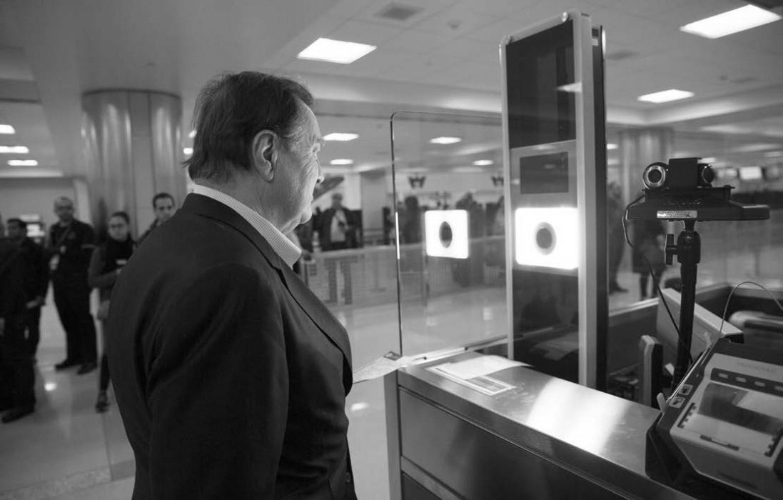 A photo of a person who stands in front of a screen to get facial recognition at the airport.