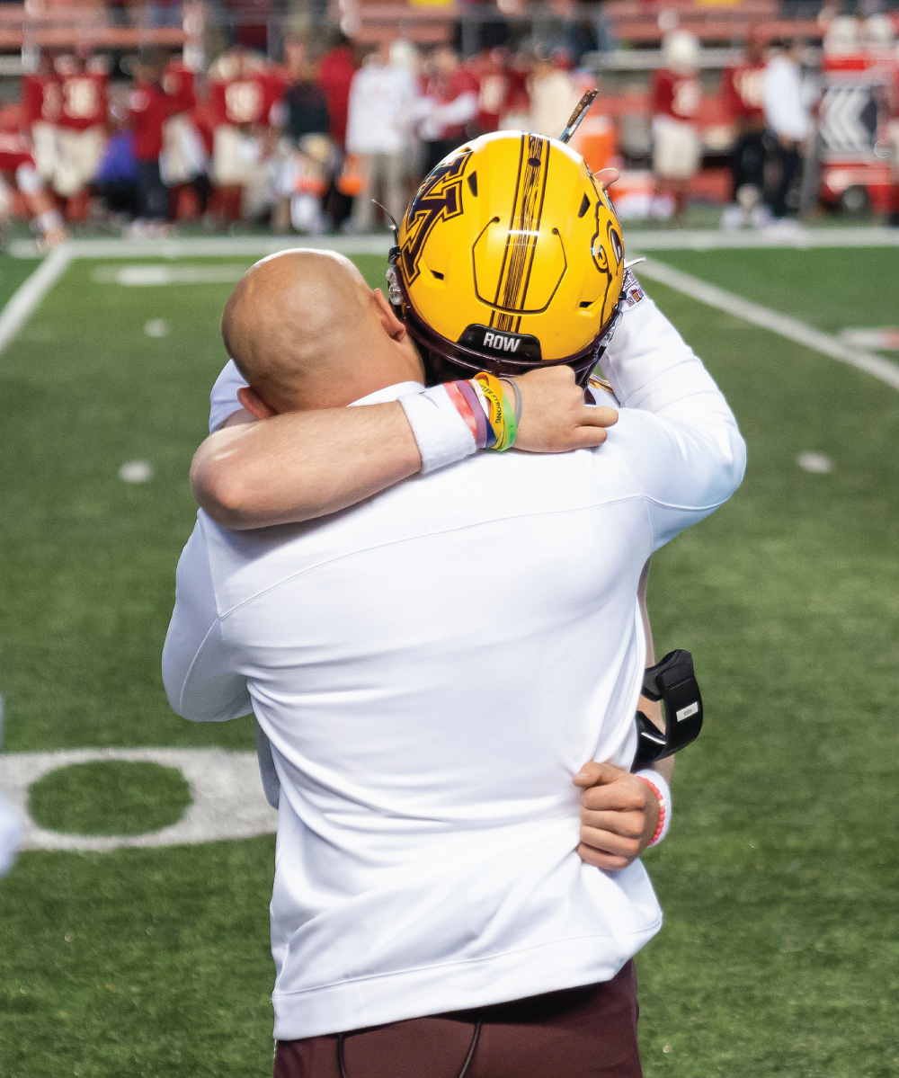 A photograph of a player and another person hugs each other.