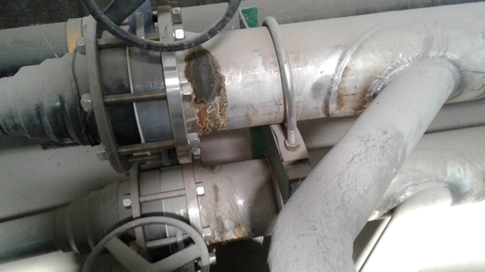 Photo depicts an example of CUI (corrosion under insulation) on a piping which is an essential part of a water treatment facility.
