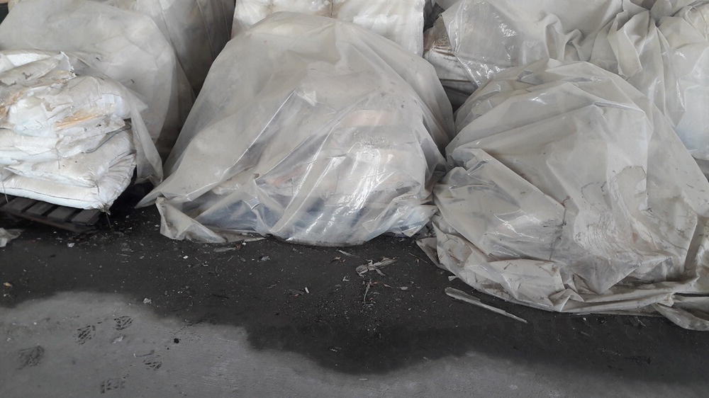 Photo depicts improper storage of calcium chloride in an open warehouse at a tropical region.