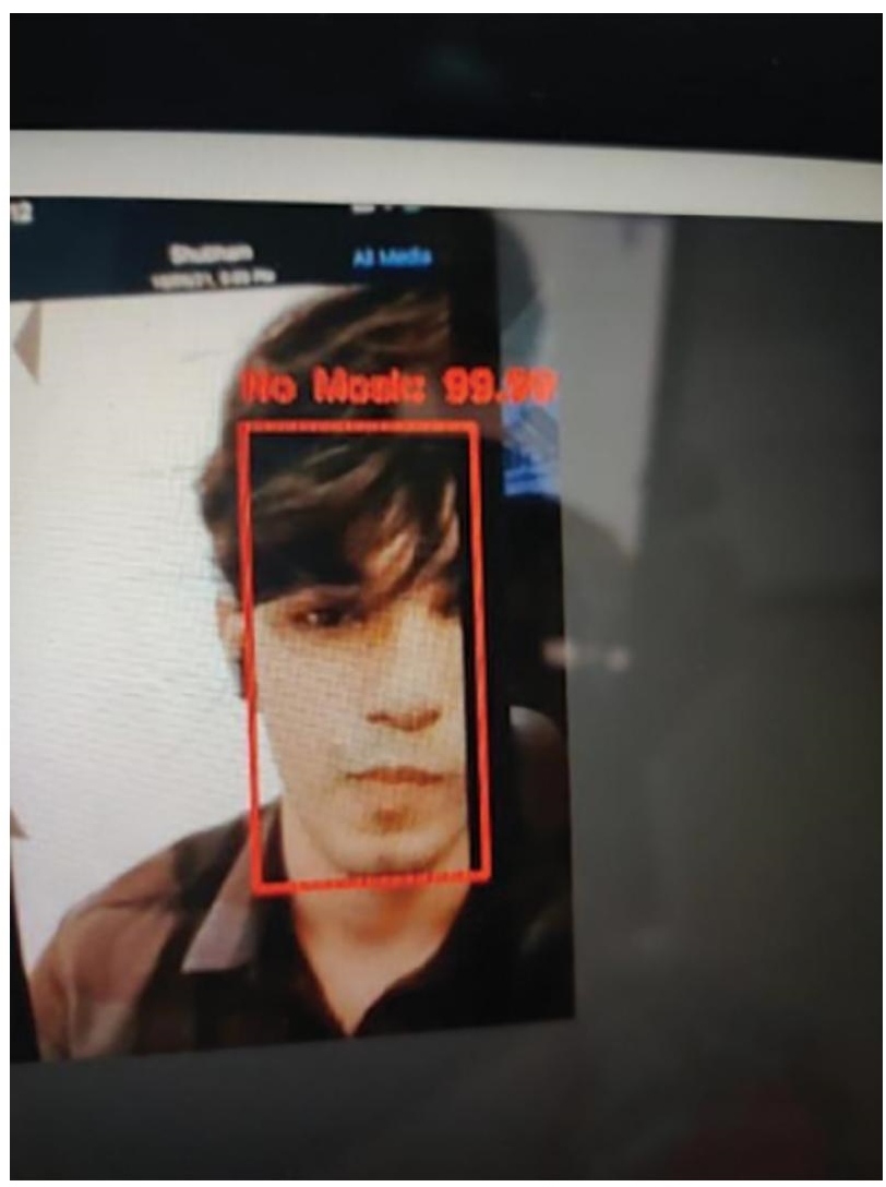 Photograph of in real time, the persons face in the image is detected without mask with 99 percentage accuracy.