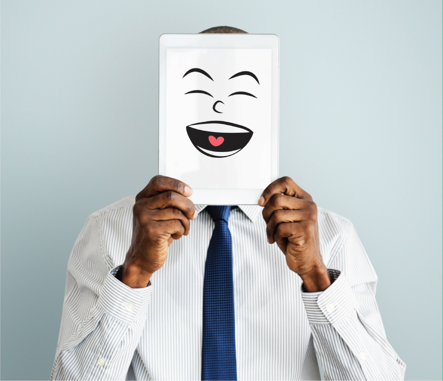 Photograph of a man holding a laughing emoji board.
