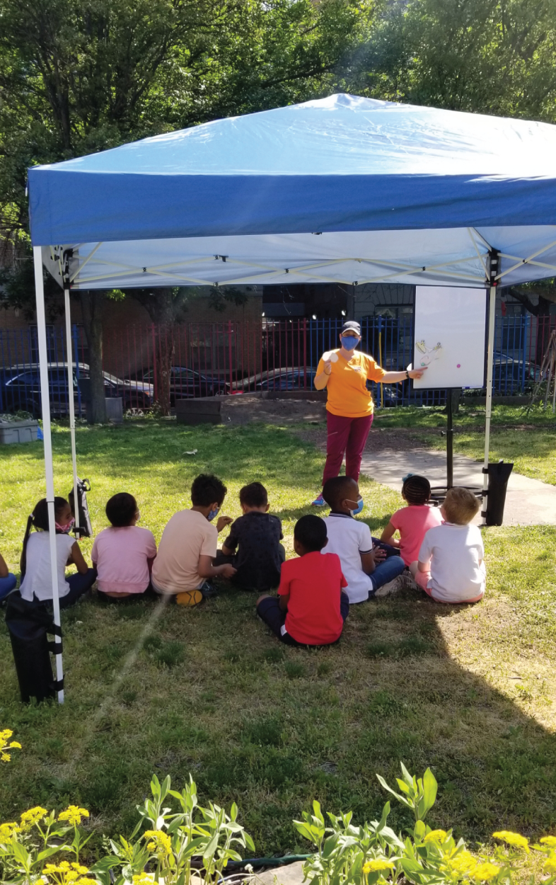 Photo depicts lesson under an awning at P.S. 185 in Harlem,
New York