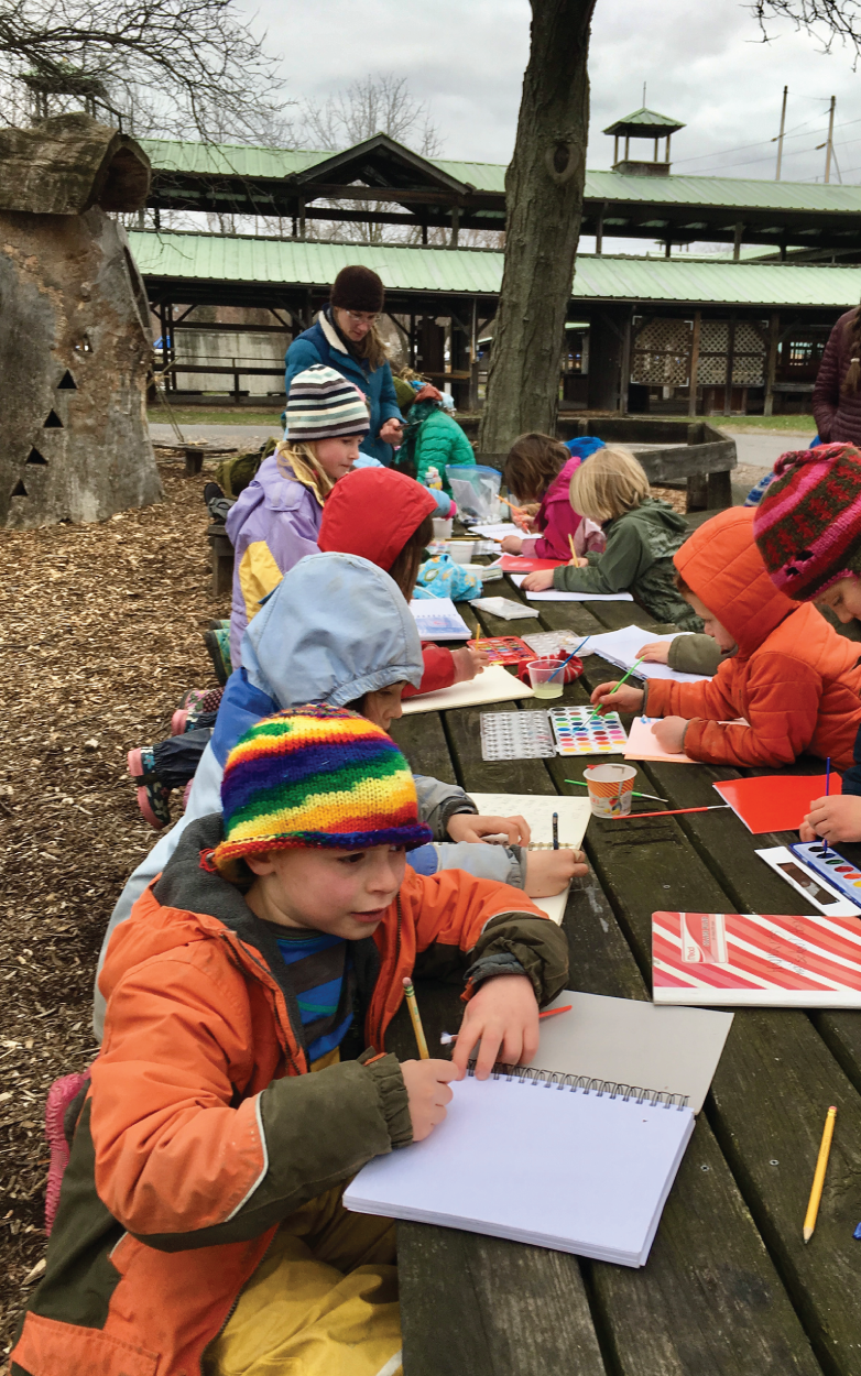 Photo depicts working outdoors on picnic tables