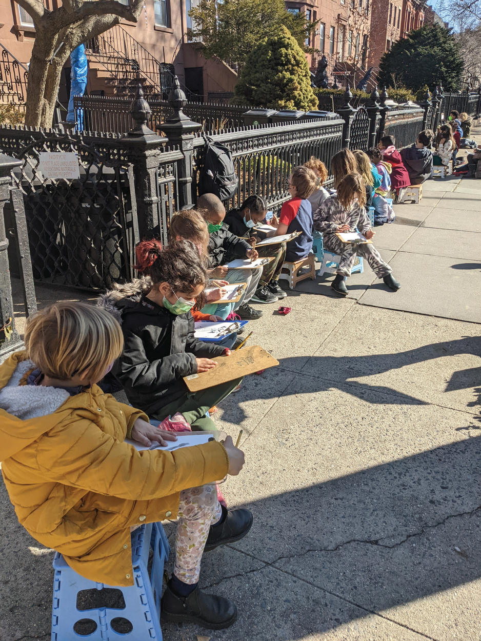 Photo depicts students drawing trees in the neighborhood