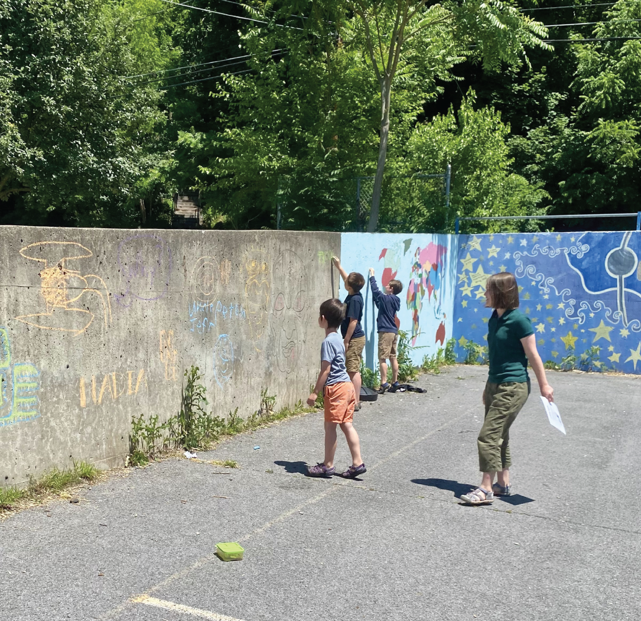 Photo depicts students working on word graffiti in the schoolyard.